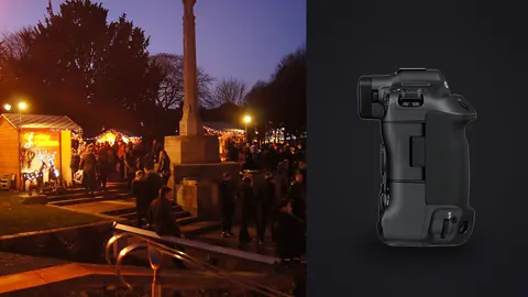Canon EOS R3 product photo beside crowd browsing wooden stalls by a war memorial at dusk