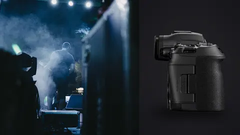 Canon EOS R5 Mark II product photo beside bassist performing on stage under yellow lights