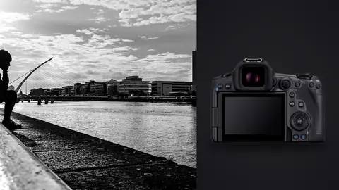 Canon EOS R5 Mark II product photo beside person sitting alone by a river with the skyline behind