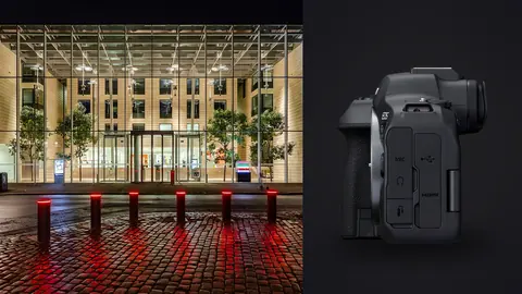 Canon EOS R6 Mark II product photo beside modern glass building entrance lit at dusk