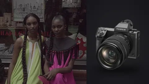 Fujifilm GFX100 II product photo beside two models in bold colorful dresses pose outside a shop window