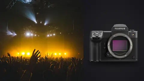 Fujifilm GFX100 II product photo beside crowd raising hands at concert with stage lights