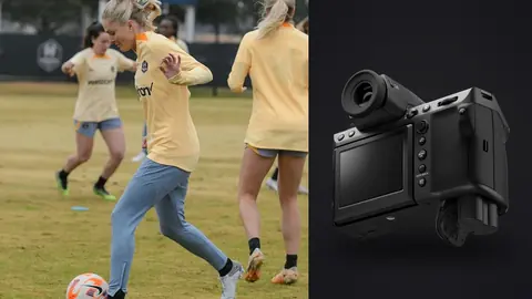 Fujifilm GFX100 II product photo beside two soccer players jogging together with a ball on grass