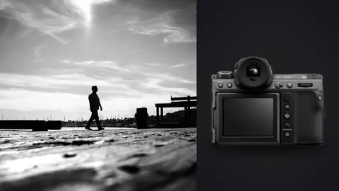 Fujifilm GFX100 II product photo beside silhouetted man walking along a sunlit marina boardwalk
