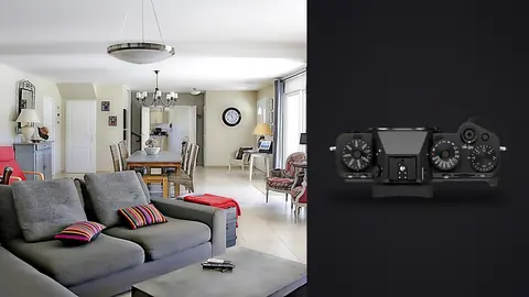 Fujifilm X-T5 product photo beside open plan living and dining room with grey sectional sofa