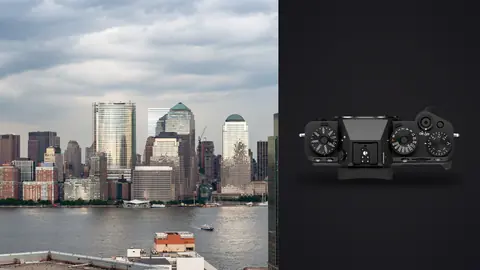 Fujifilm X-T5 product photo beside city skyline of high-rise towers across a river