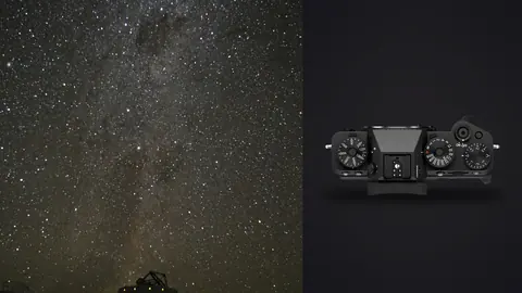 Fujifilm X-T5 product photo beside milky way band above a distant observatory silhouette