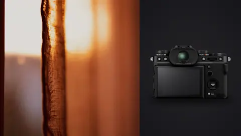 Fujifilm X-T5 product photo beside warm curtain edge glowing with sun flare