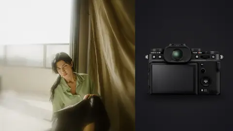 Fujifilm X-T5 product photo beside woman in green shirt seated by window in soft light