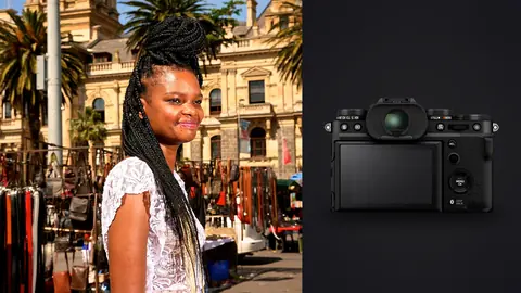 Fujifilm X-T5 product photo beside woman with long braided hair smiles on a market street