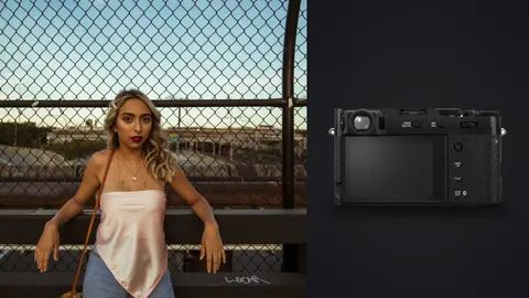 Fujifilm X100VI product photo beside woman in a pink cami and jeans leans against a chain link fence