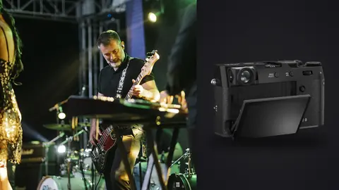 Fujifilm X100VI product photo beside bassist and dancer performing on stage under green lights