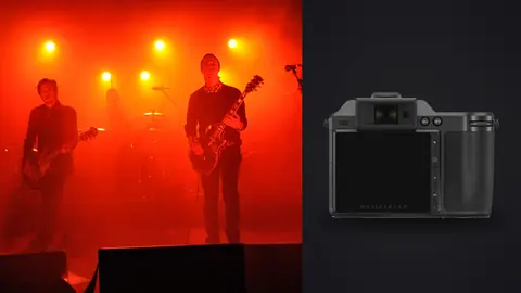 Hasselblad X2D 100C product photo beside band performing on stage under red lights