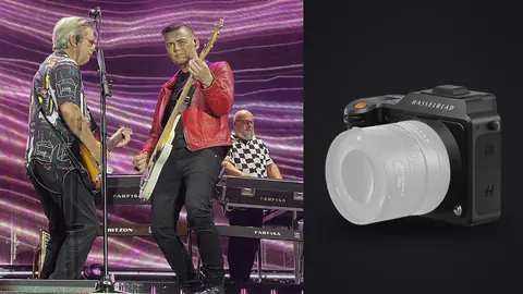 Hasselblad X2D 100C product photo beside two guitarists performing on stage under purple lights