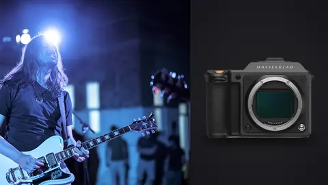 Hasselblad X2D 100C product photo beside guitarist performing on stage with bright backlight