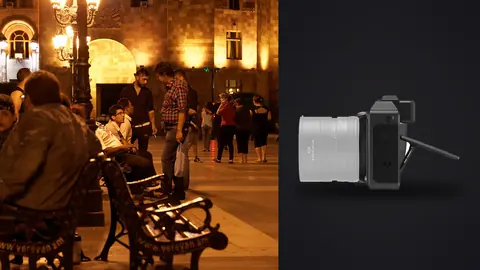 Hasselblad X2D 100C product photo beside people gathered on benches in a lit plaza at night
