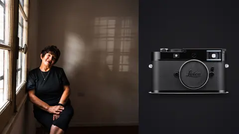 Leica M11 product photo beside older woman seated by window in a dark room