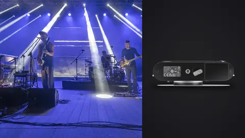 Leica M11 product photo beside band performing on stage with dramatic blue lighting