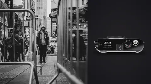 Leica M11 product photo beside two men standing near a barred storefront window