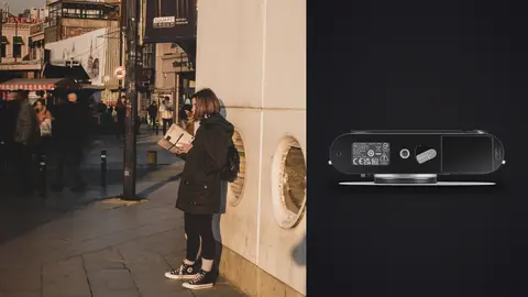 Leica M11 product photo beside woman with a backpack looking up at a building corner