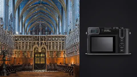 Leica Q3 product photo beside blue and gold vaulted ceiling above an ornate choir screen