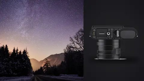Leica Q3 product photo beside vivid milky way over a snowy mountain road at night