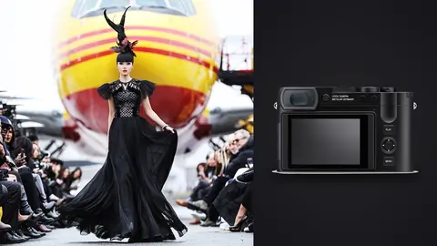 Leica Q3 product photo beside model in dramatic black gown with feathered headpiece on runway