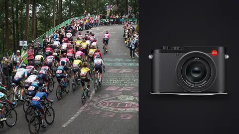 Leica Q3 product photo beside cyclists climbing a forest road between cheering crowds with chalk art