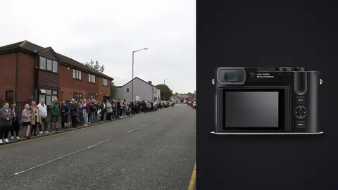 Leica Q3 product photo beside crowd lining a residential street watching a parade
