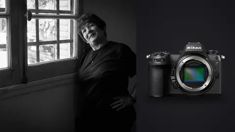 Nikon Z6 III product photo beside older woman standing by window in black outfit