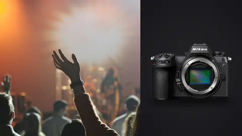 Nikon Z6 III product photo beside crowd raising hands at concert under orange light