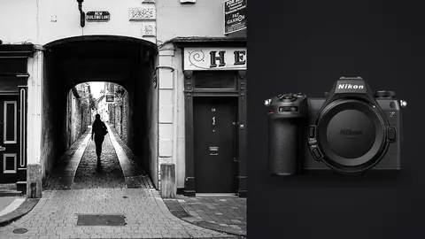 Nikon Z6 III product photo beside silhouetted figure walking through a stone archway passage