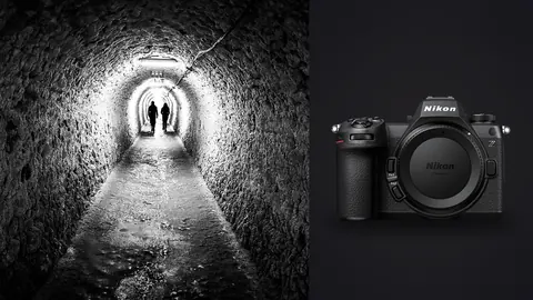 Nikon Z6 III product photo beside two silhouettes walking through a round underground tunnel