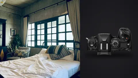 OM System OM-1 Mark II product photo beside bedroom with industrial windows and potted plants