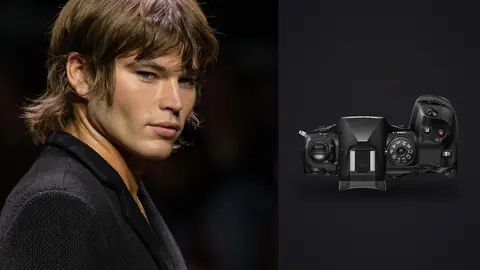 OM System OM-1 Mark II product photo beside male model in a dark jacket with tousled hair