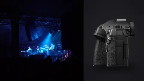 OM System OM-1 Mark II product photo beside band performing on stage viewed from the back of the venue