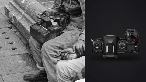 OM System OM-1 Mark II product photo beside street shoeshine worker with polish box and client seated
