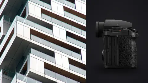 Panasonic Lumix S5IIX product photo beside geometric pattern of white balconies on a modern tower