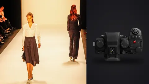 Panasonic Lumix S5IIX product photo beside two models in tailored outfits walking a bright runway