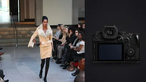 Panasonic Lumix S5IIX product photo beside model in a tan suit walking a runway