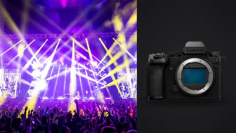 Panasonic Lumix S5IIX product photo beside concert stage with purple and yellow lights and crowd