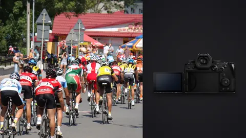 Panasonic Lumix S5IIX product photo beside large cycling peloton riding through a town in national jerseys