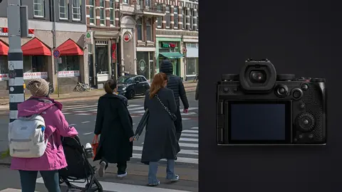 Panasonic Lumix S5IIX product photo beside two women crossing a pedestrian crossing in a city