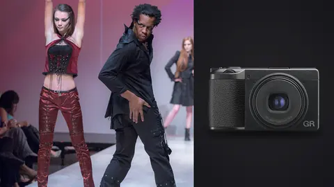 Ricoh GR IIIx product photo beside two models in edgy black and red outfits posing on stage