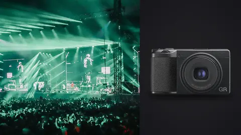 Ricoh GR IIIx product photo beside concert stage with green lights and crowd