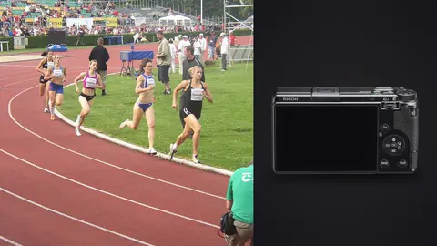 Ricoh GR IIIx product photo beside group of female distance runners racing along a track curve