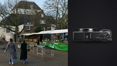 Ricoh GR IIIx product photo beside two people walking past an outdoor market stall