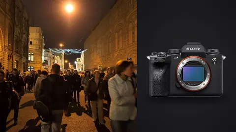Sony Alpha 1 product photo beside dense crowd walking a lit city street at night