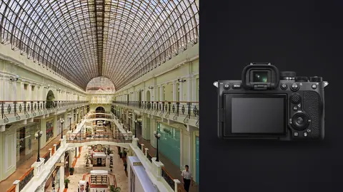 Sony a7 IV product photo beside elegant glass-roofed arcade with tiered balconies