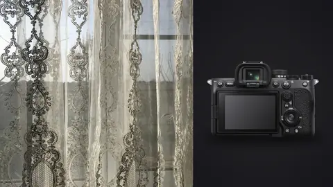 Sony a7 IV product photo beside ornate lace curtain pattern close-up